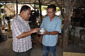 Engr. Leoncio T. Cubillas, Jr., one of the mentors of the Citi Microentrepreneurship Awards Mentoring Program, examines the finished product, a recycled can, of Ismael Adiaton of Taytay, Rizal. 